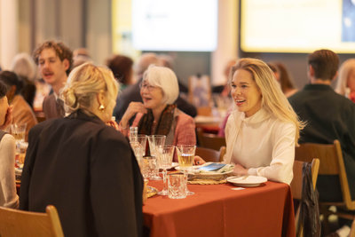 Guests invited to an event sit at a set table in the Van Gogh Museum.