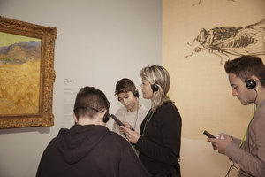 Young people are listening to the audio guide near Van Gogh's painting Wheatfield with a Reaper at the van Gogh Museum. Photo: Maaike Koning 