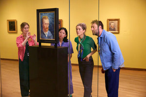 Een groepje bezoekers kijkt tijdens een rondleiding naar een schilderij dat op de achterkant van een zelfportret van Vincent van Gogh is geschilderd in het Van Gogh Museum. Foto: Suzanne Karsters